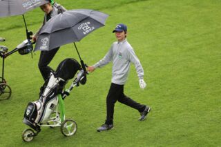 junger Golfer mit Trolley